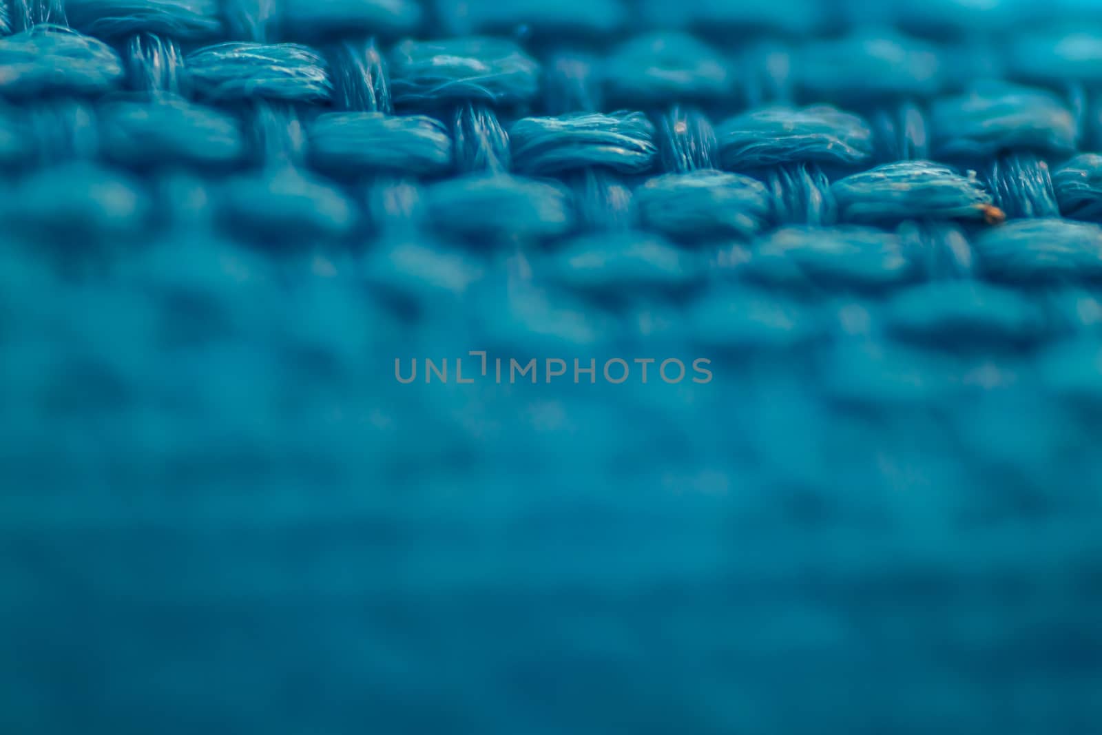 a macro shoot of braided blue cloth texture. focus on top side of picture.