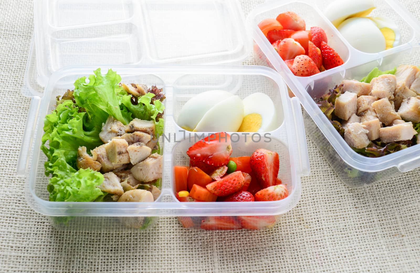 Modern style clean food, boiled egg, grilled chicken and avocado, strawberry, vegetable salad