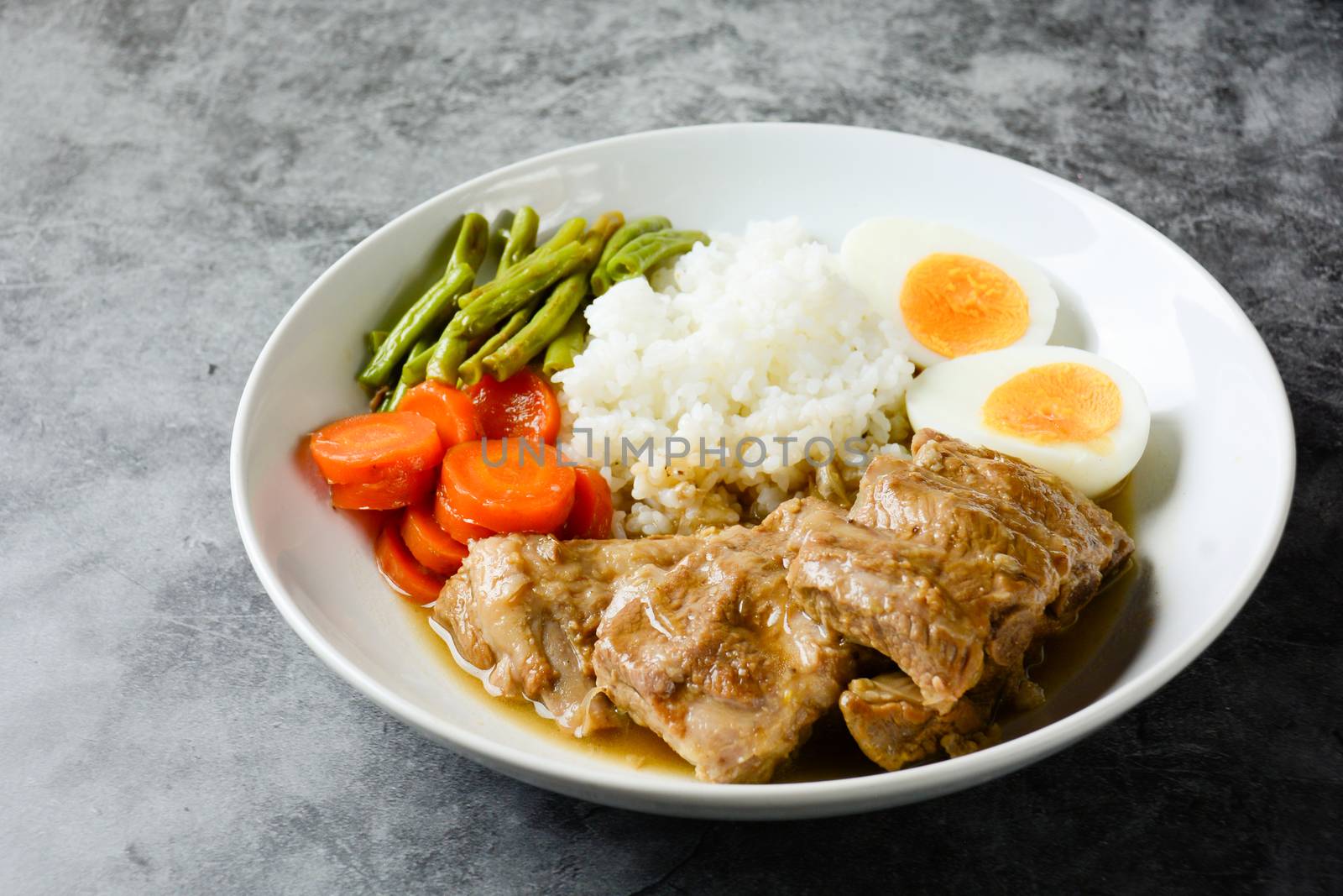 Baked pork ribs with rice, boiled egg and vegetable