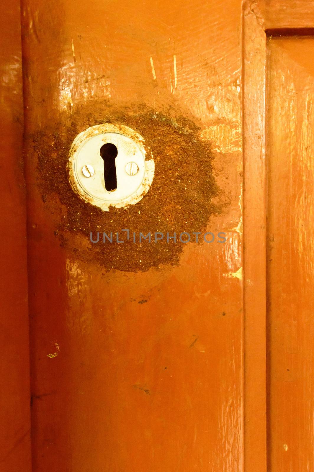 Closeup front view exterior old rusty rough brown wooden door keyhole of iron metal frame with in grungy style and good texture of a closed door of a domestic living room. Architecture background. by sudiptabhowmick
