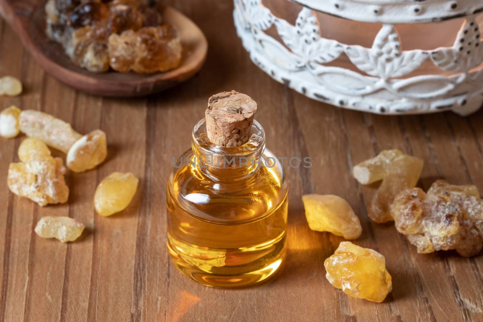 A bottle of essential oil with frankincense resin crystals