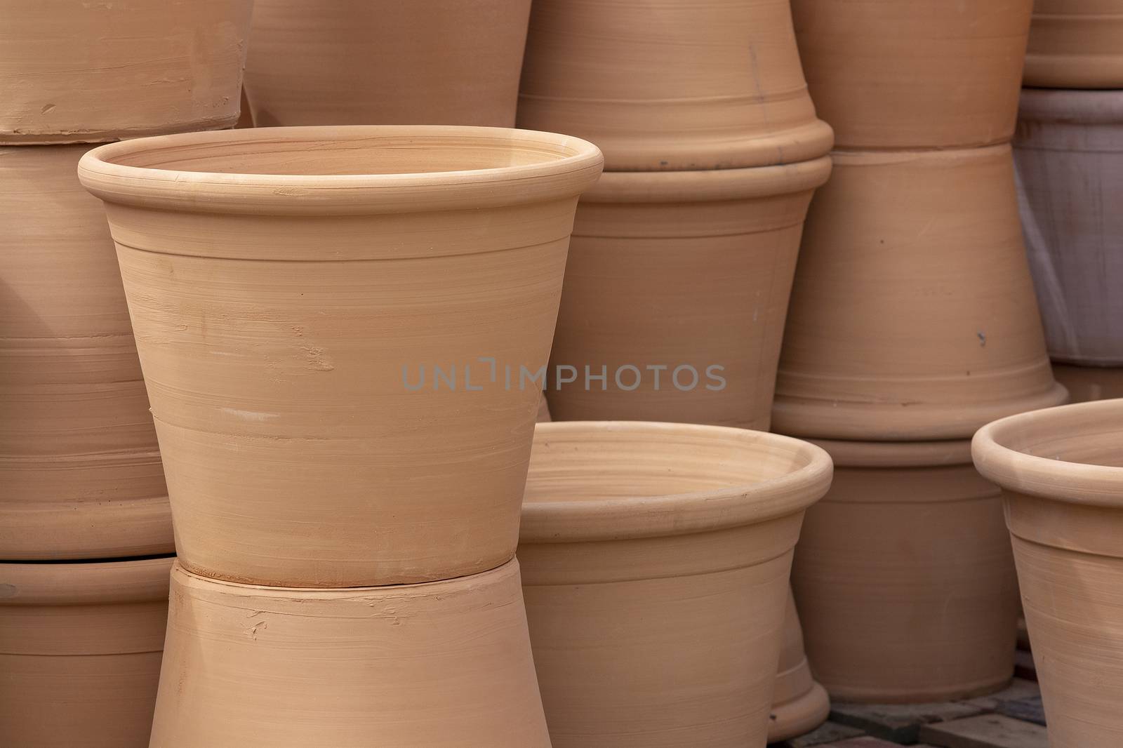 Rustic terracotta pots piled up on display closeup full frame