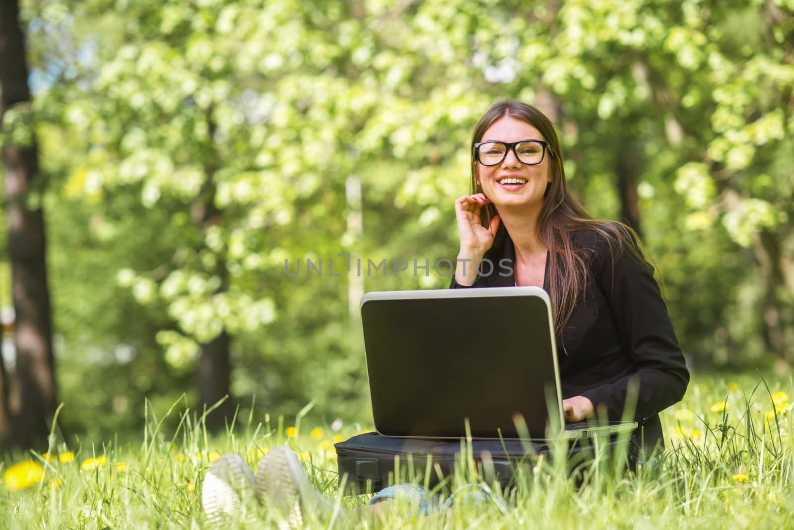 Business woman with laptop in park by ALotOfPeople