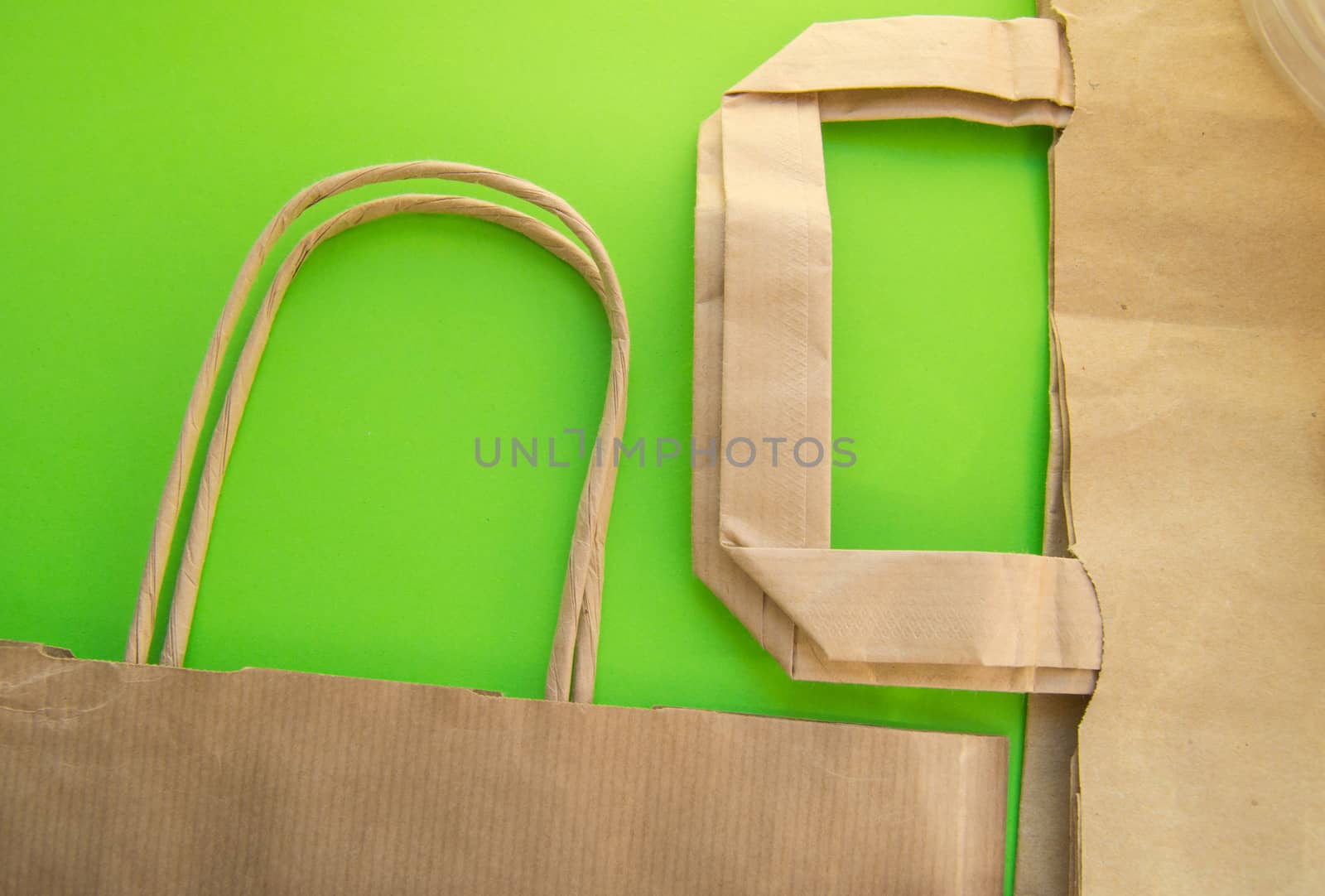 Zero waste, plastic free recycled production bag into paper bag, environmental protection concept, top view, green background, flat lay by claire_lucia