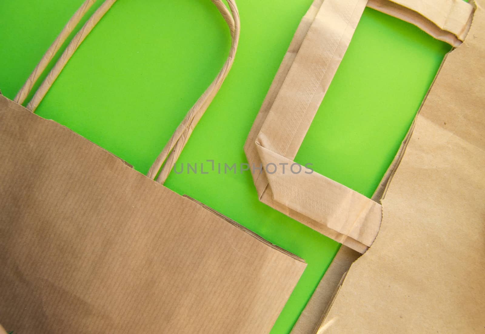 Zero waste, plastic free recycled production bag into paper bag, environmental protection concept, top view, green background, flat lay, copy space