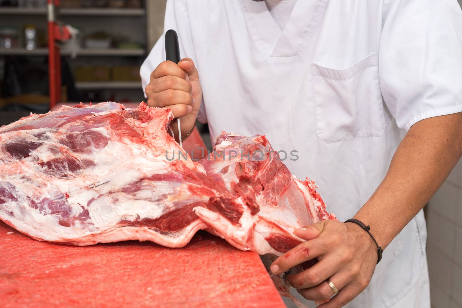 butcher cutting a large piece of meat by HERRAEZ