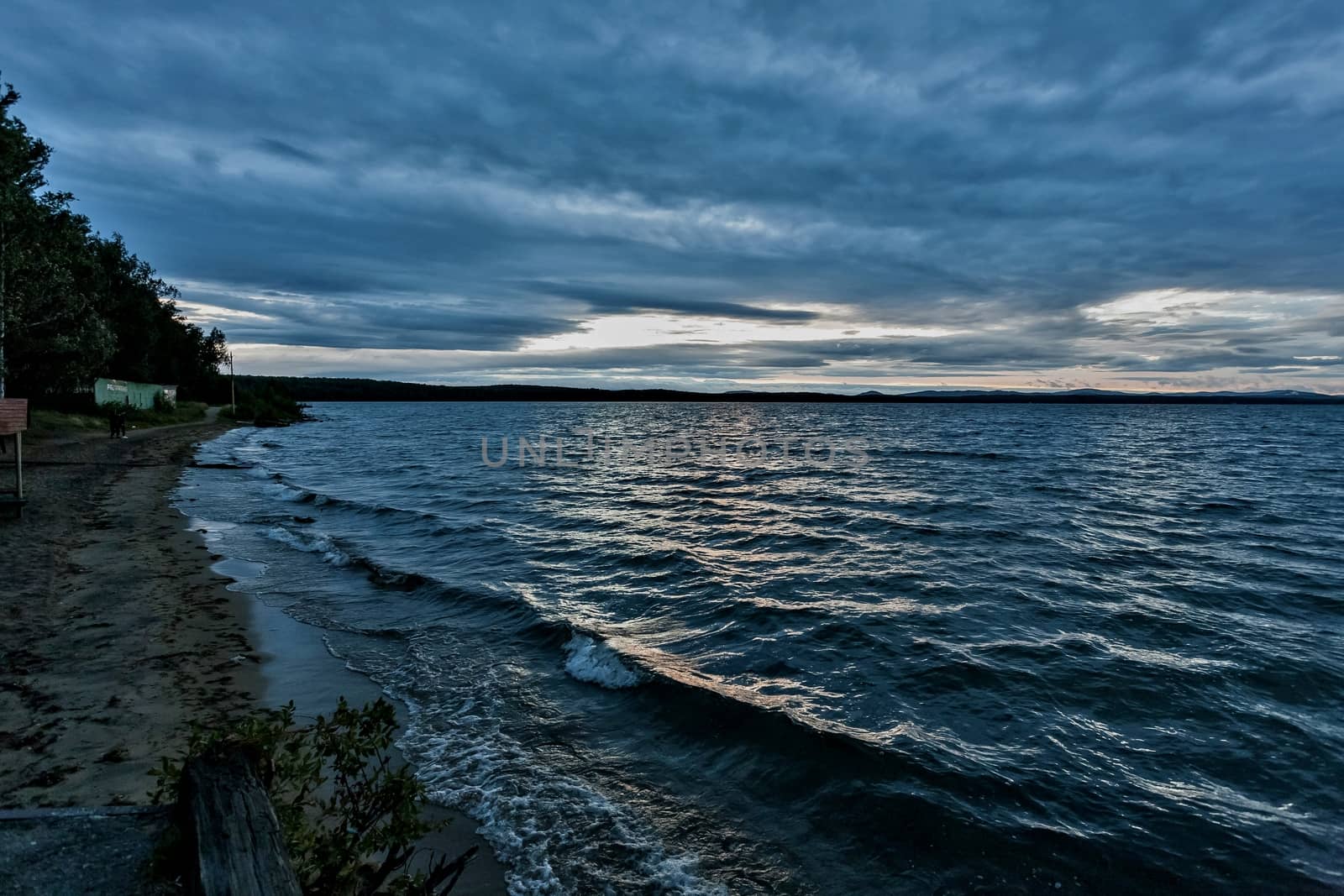 dark blue evening cloudy sky over the lake by valerypetr