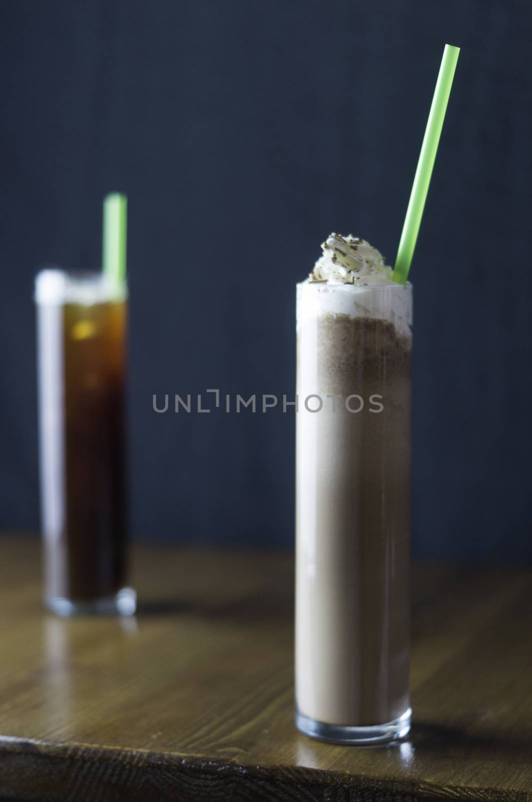 the service desk with a glass of iced tea and placed a glass of cold chocolate and green pipette