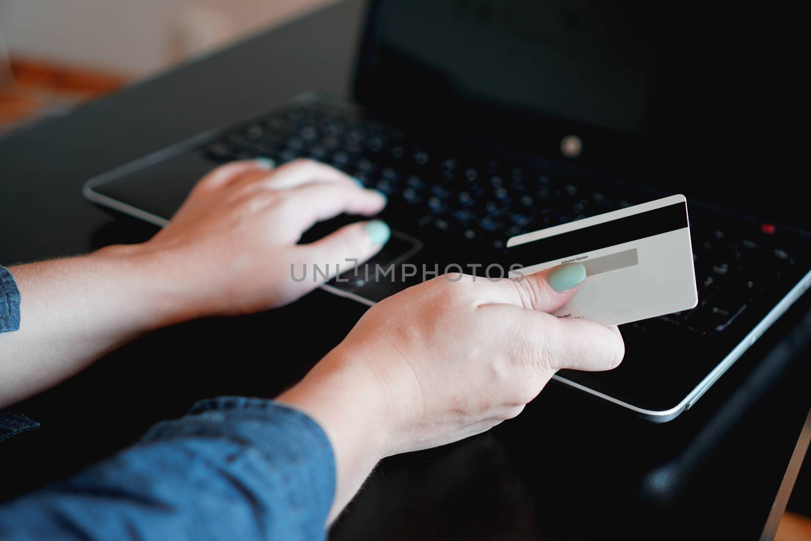 Hands holding credit card and using laptop. Online shopping.