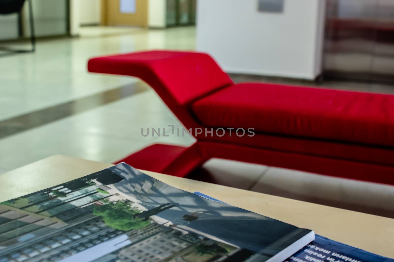 a closeup perspective shoot of a red sofa - focus on magazines. photo has taken from an university at izmir/turkey.