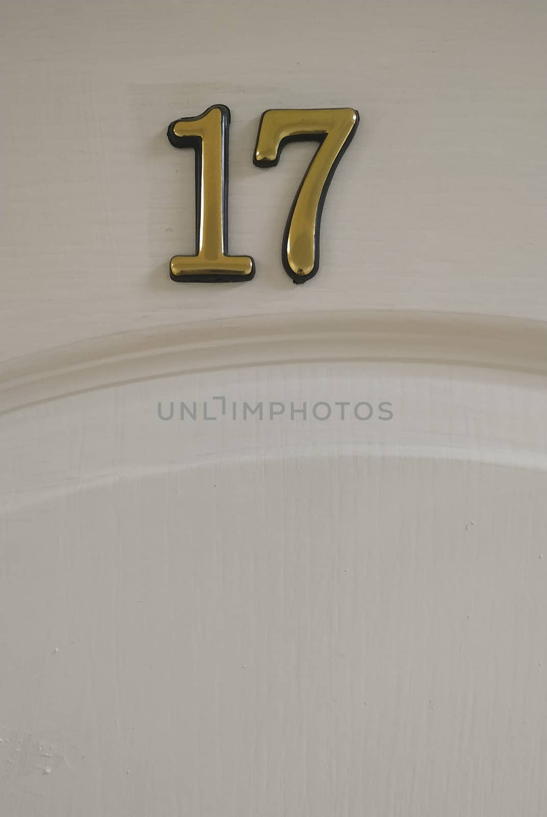 Fragment of a white door with a volume number of 17. Background.