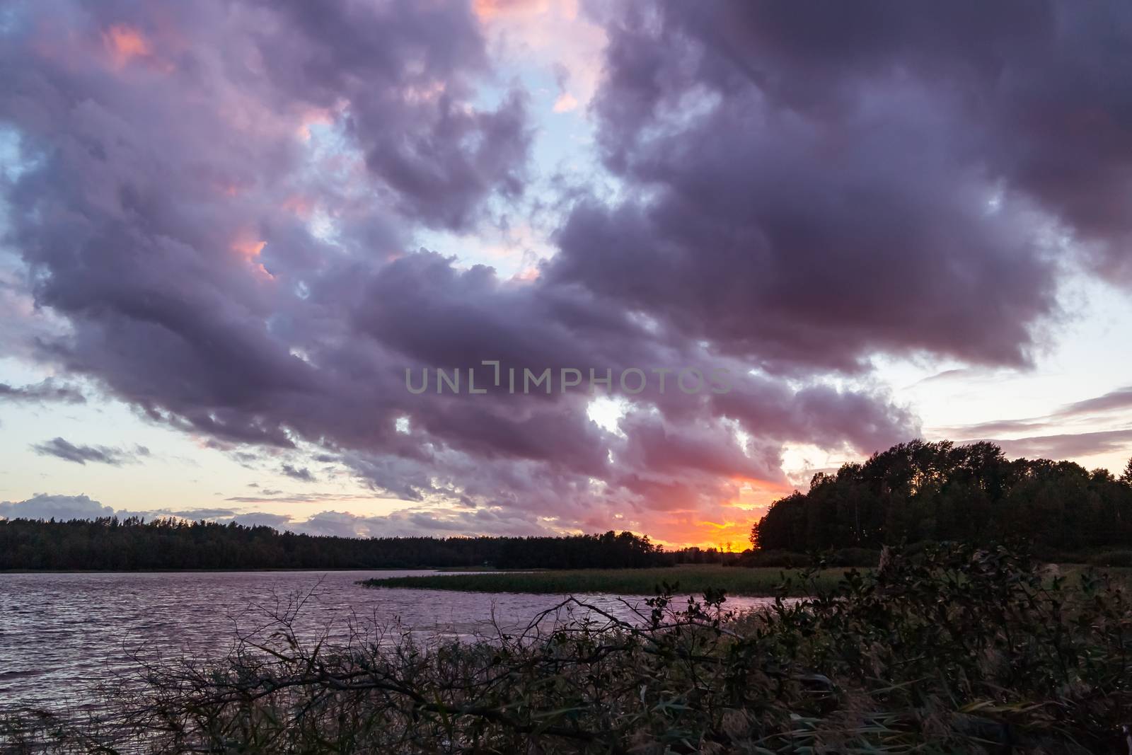 Beautiful colorful sunset on the lake, sunlight through dramatic clouds, evening summer landscape - photo, image by galsand