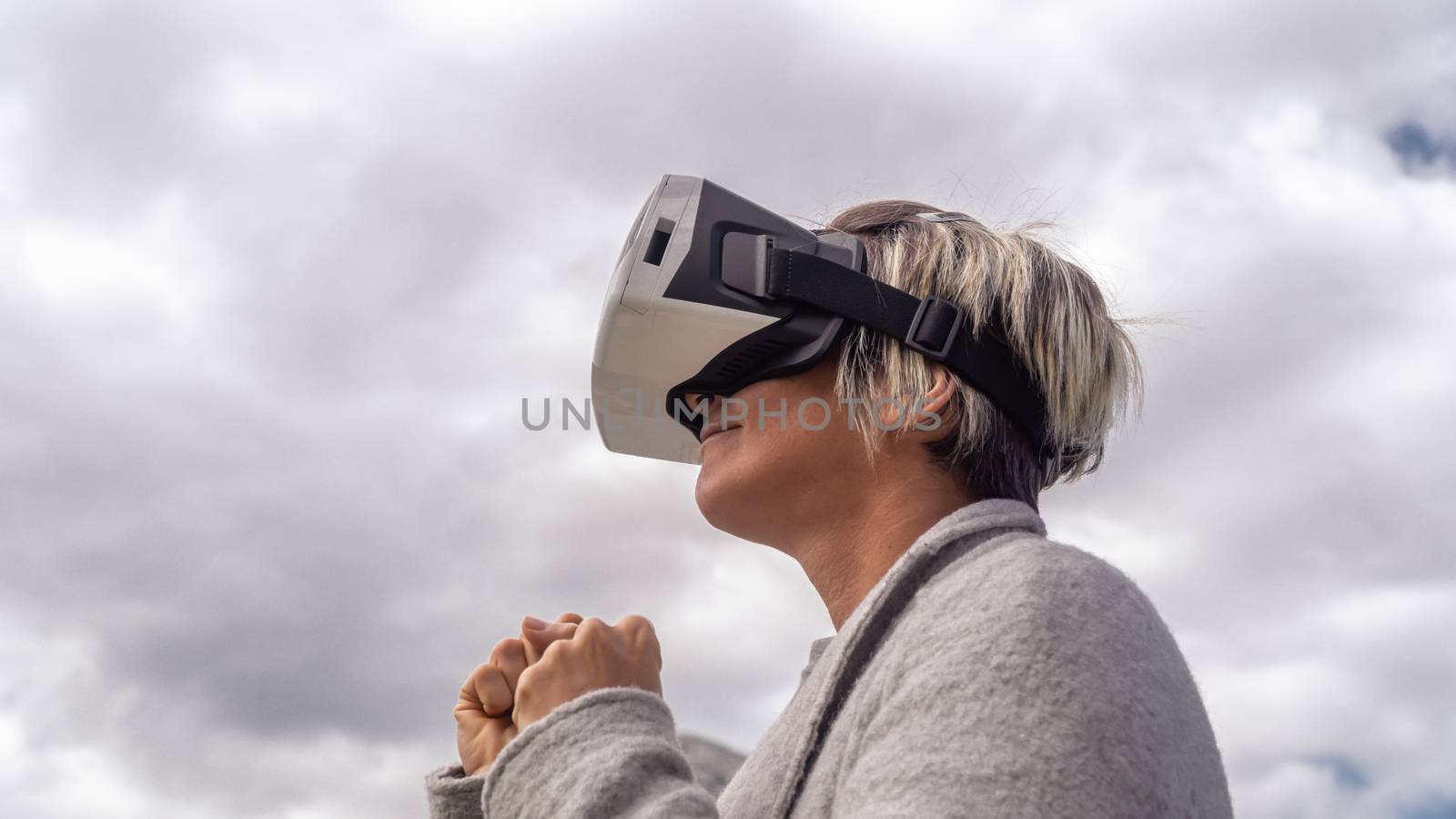 Woman in the nature wearing augmented reality goggles. by Emurado