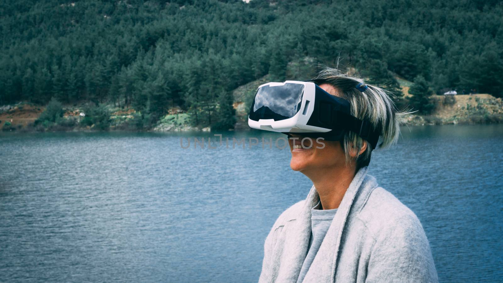 Woman in the nature wearing augmented reality goggles. by Emurado