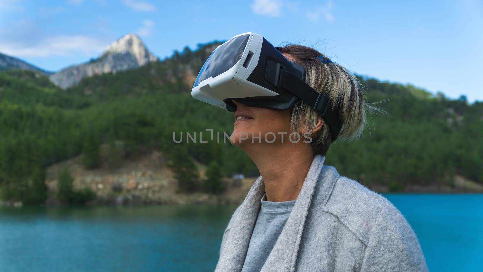 Woman in the nature wearing augmented reality goggles. by Emurado