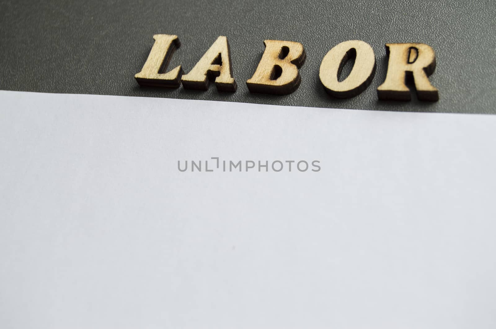 The word labor written in wooden letters to celebrate labor Day in may. Ready design layout for advertising with empty space for text.