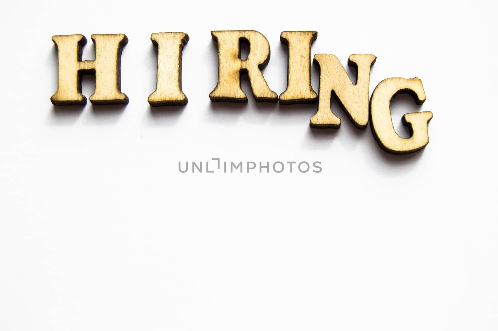 The word hiring is written in gold letters, isolated on white background, copy space, mockup for designer.