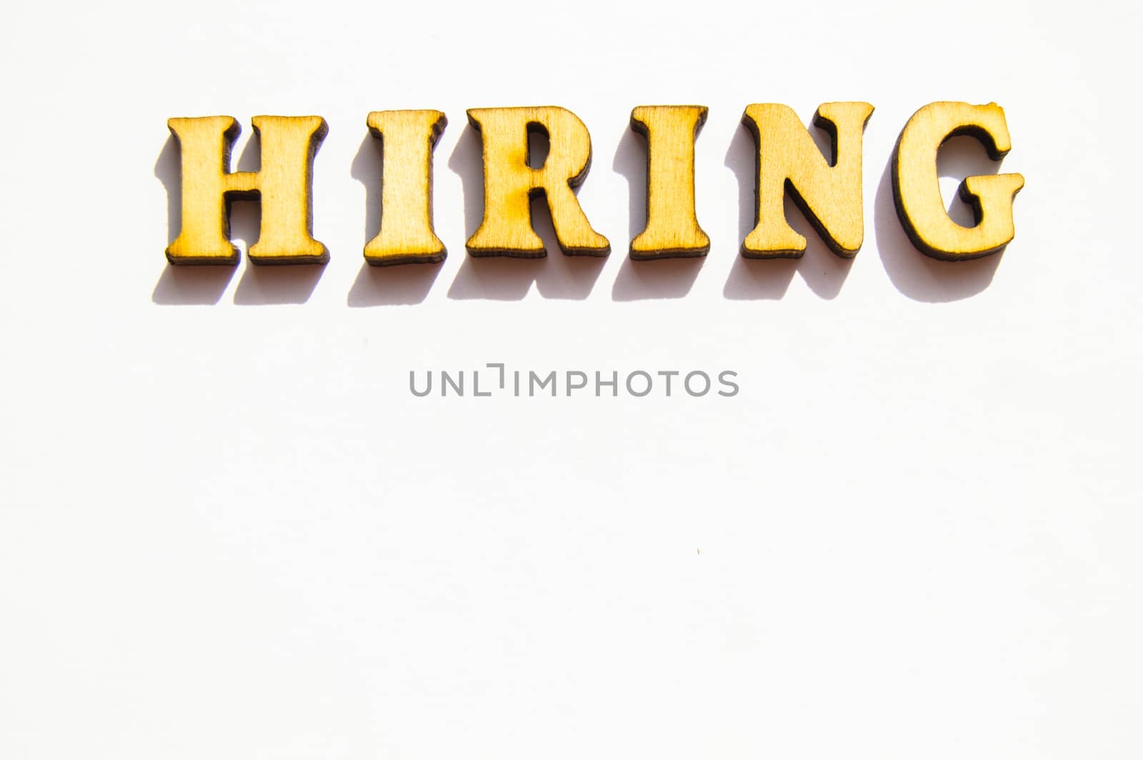 The word hiring is written in gold letters, isolated on white background, copy space, mockup for designer.