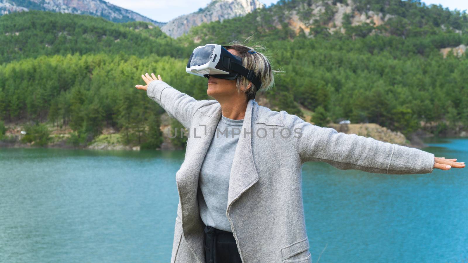 Adult female having fun with AR glasses on. Flying. Playing.Daytime.