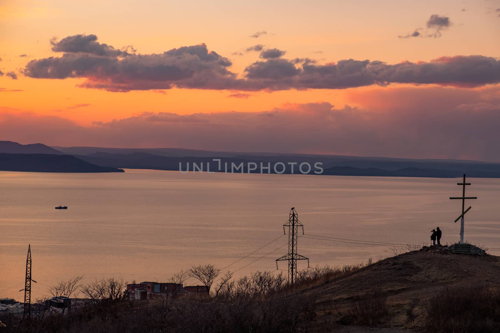 View of the city of Vladivostok from the hill eagle's nest . Sunset. The sky is orange and pink. Sea and city at sunset.