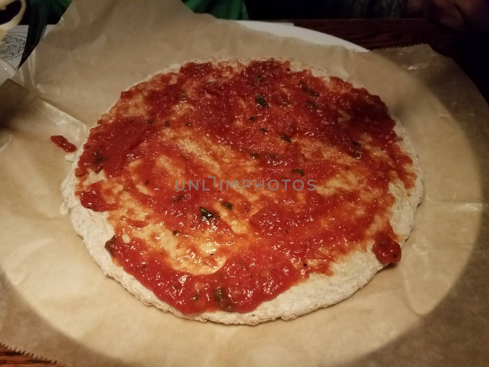 pizza dough and tomato sauce on wax paper by stockphotofan1