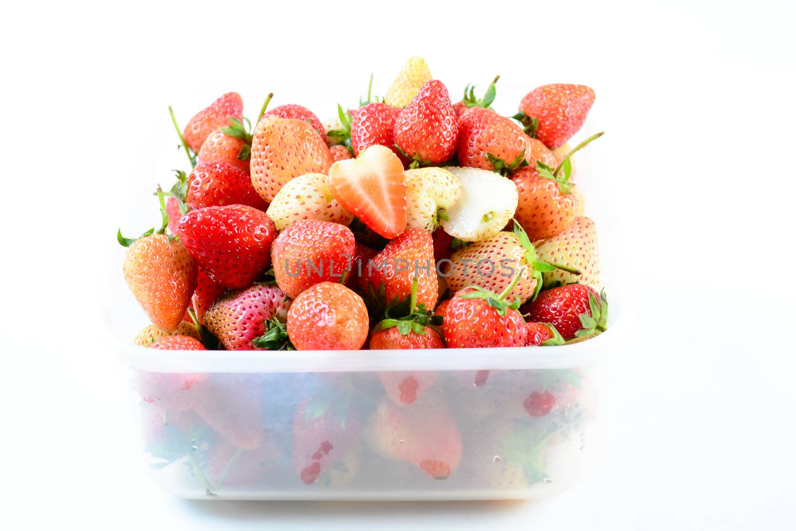 Fresh strawberries in white transparant box on white background