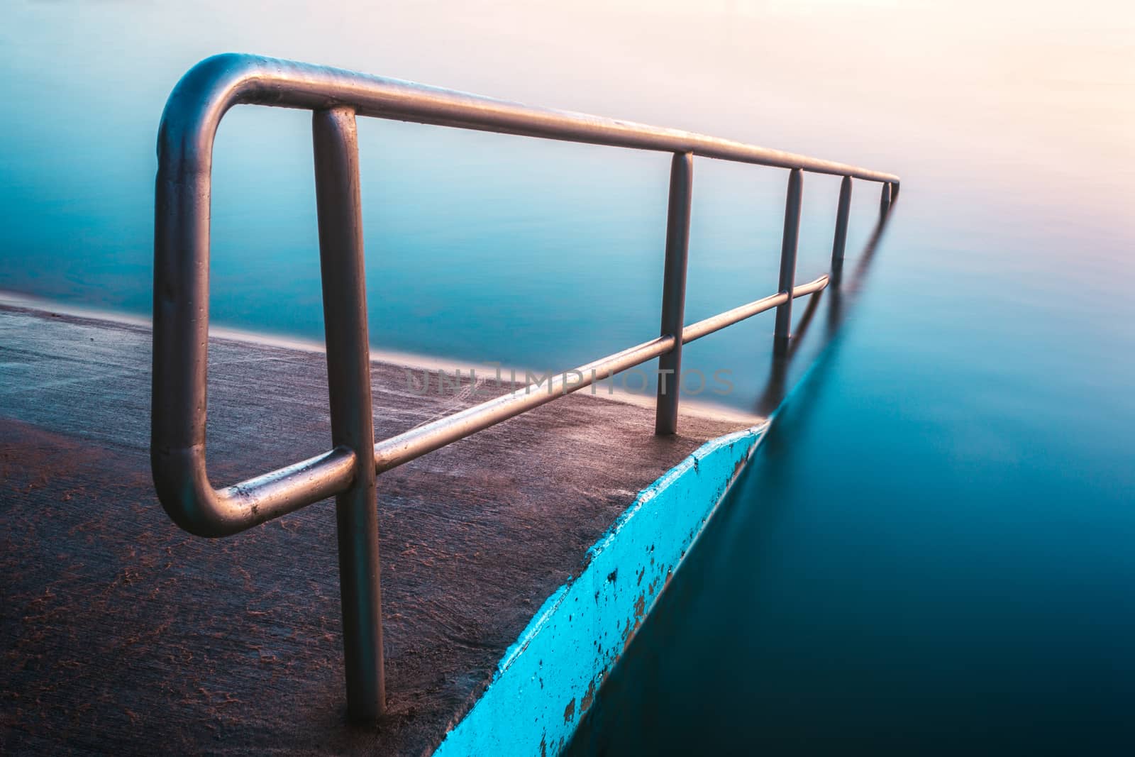 Lovely blues and pinks of the dawn relfected in the North Narrabeen rock pool in the northern beaches of Sydney Australia