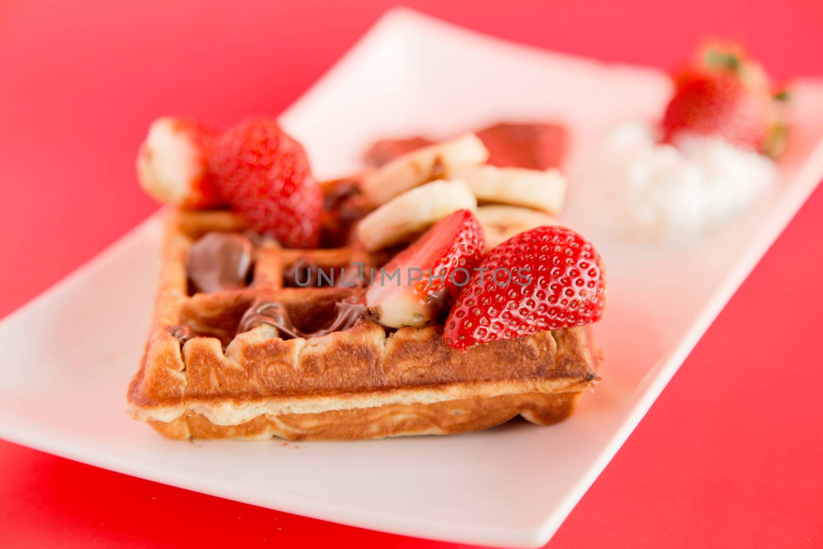 Strawberry and Banana Waffle on red background by haiderazim