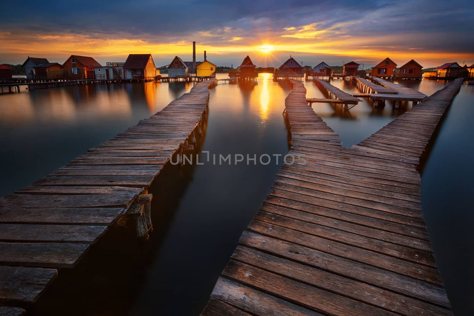 Sunset over lake Bokod with wooden pier and floating houses, Hungary by zhu_zhu