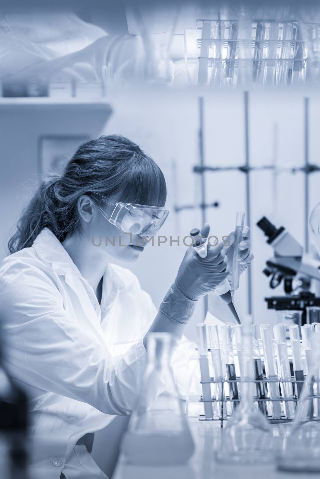 Young scientist pipetting in life science laboratory. by kasto