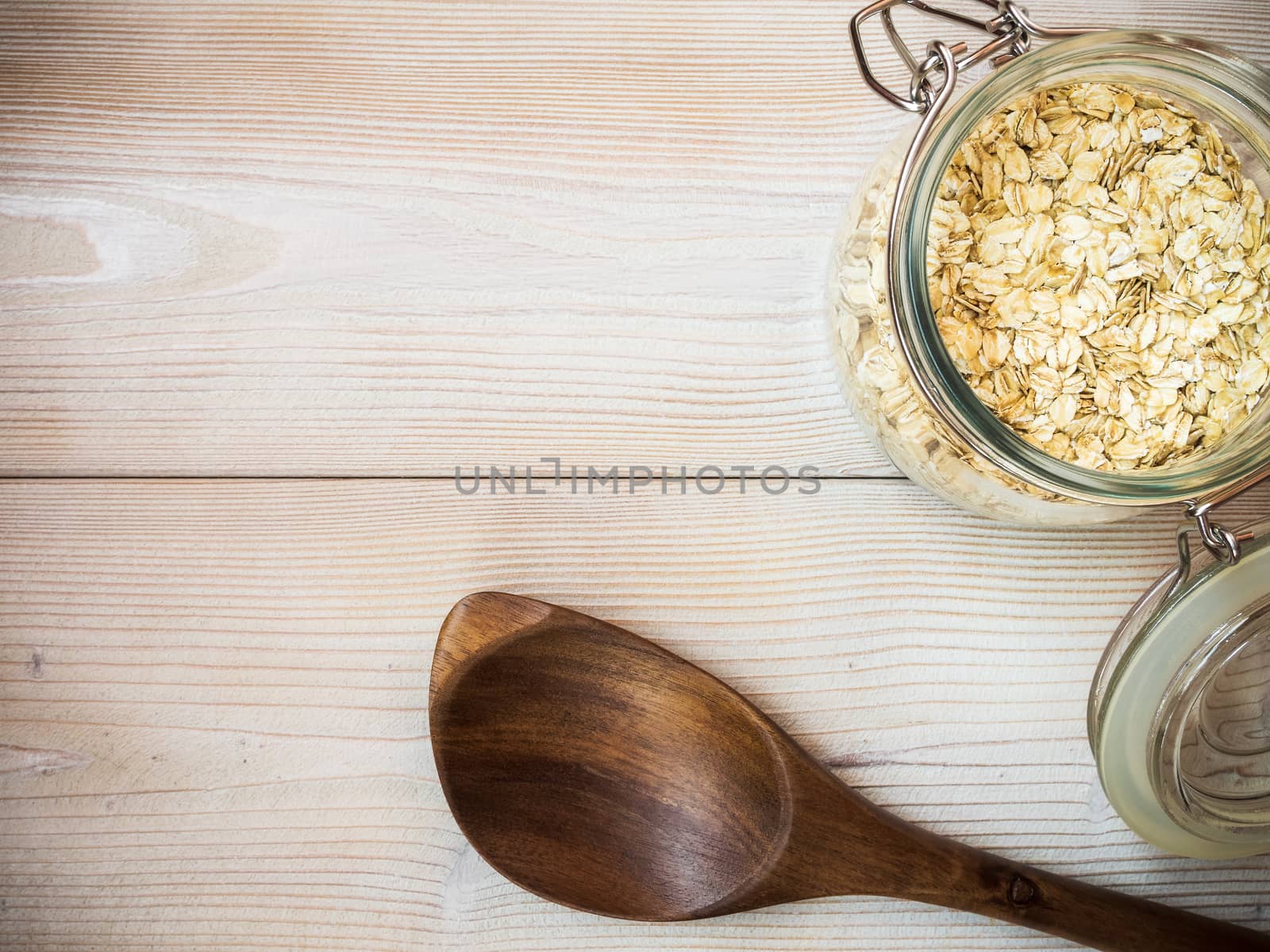 Glass jar with oat-flakes on the wooden background. View from above