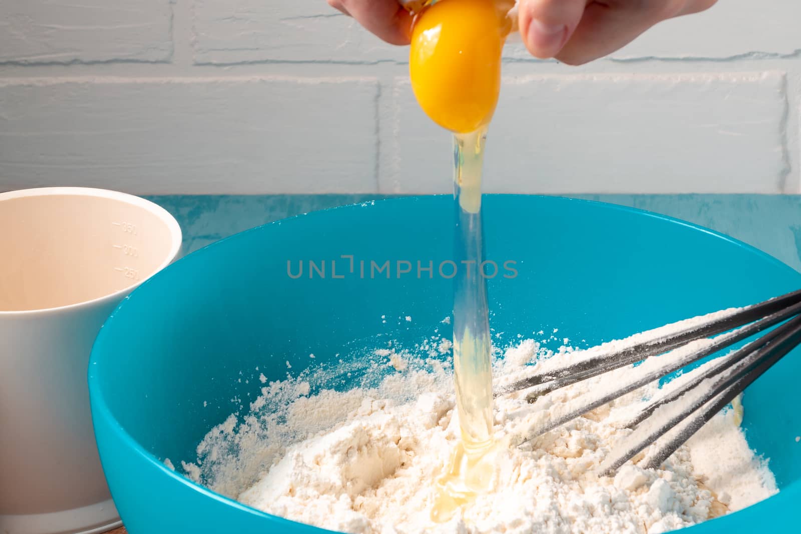 Breaking an egg into flour while preparing the dough - photo, image.