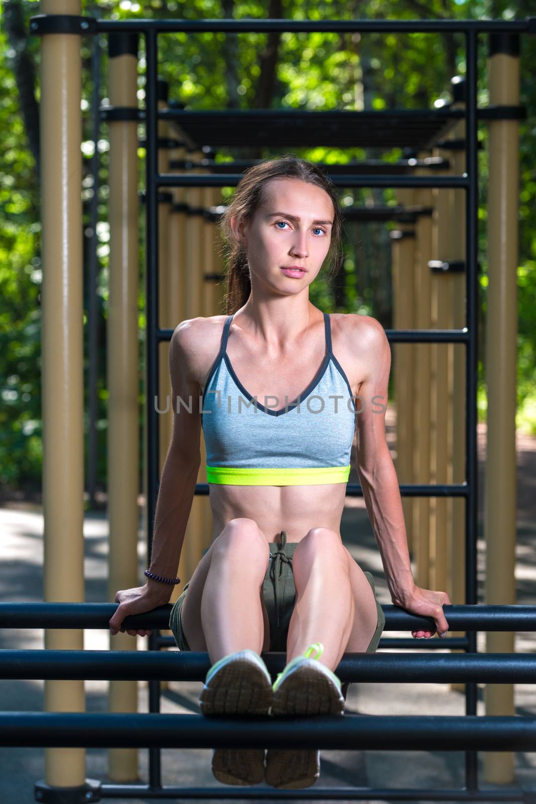 portrait of slim athletic girl on a sports simulator during a workout in the fresh air