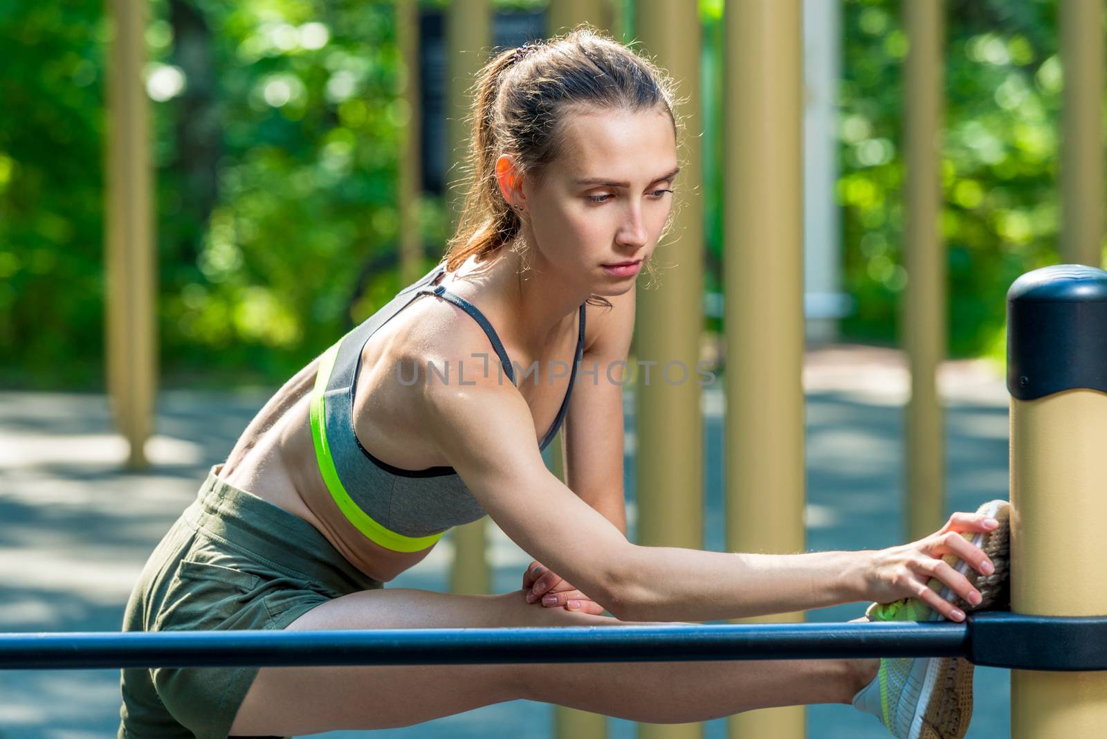 Stretching on the playground in the summer morning, portrait of a sports woman