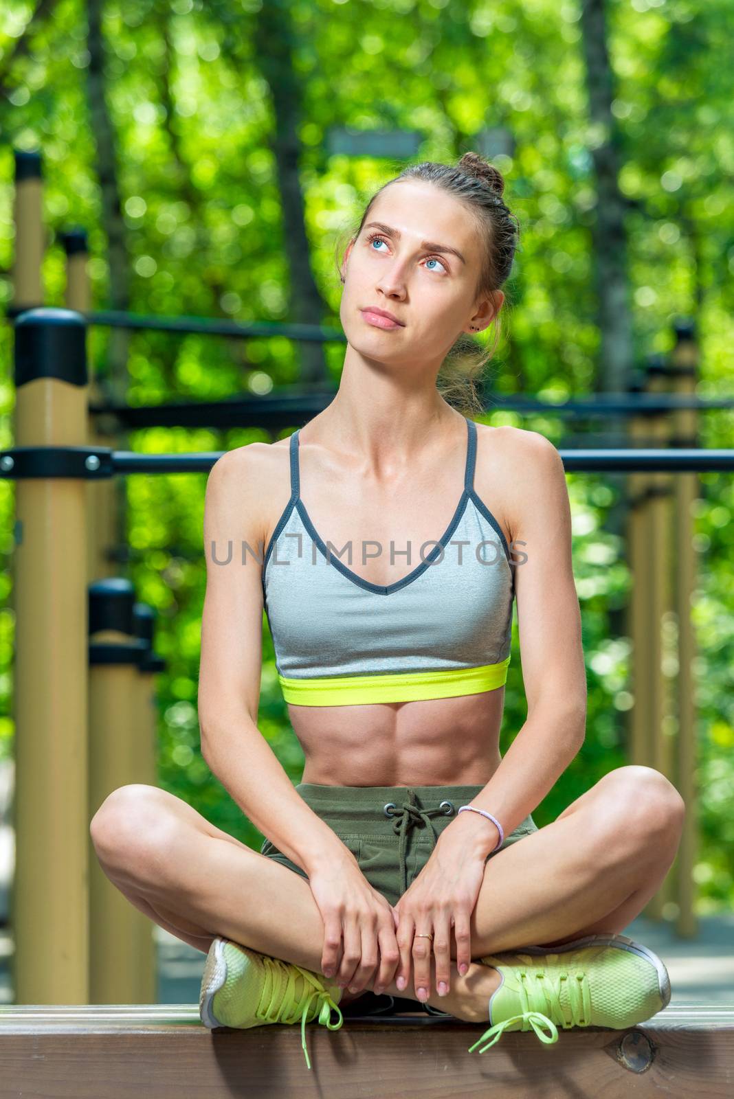 pensive girl athlete relaxes on the sports field, vertical portrait