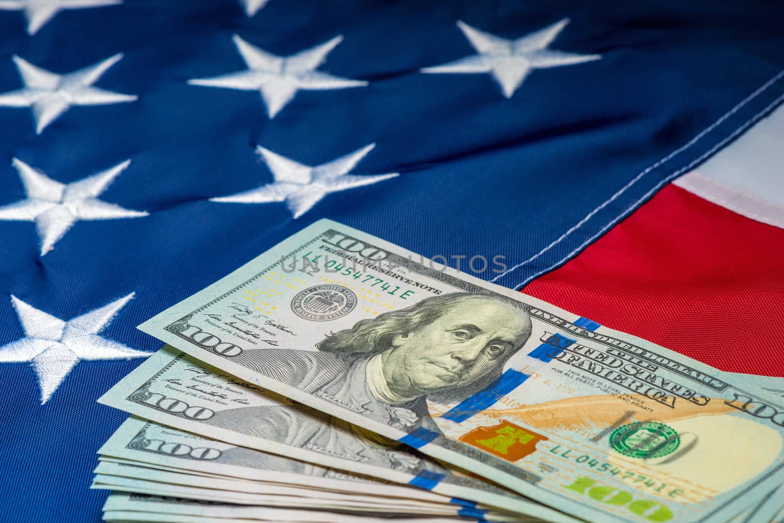 a lot of money 100 dollars on the background of the American flag close up