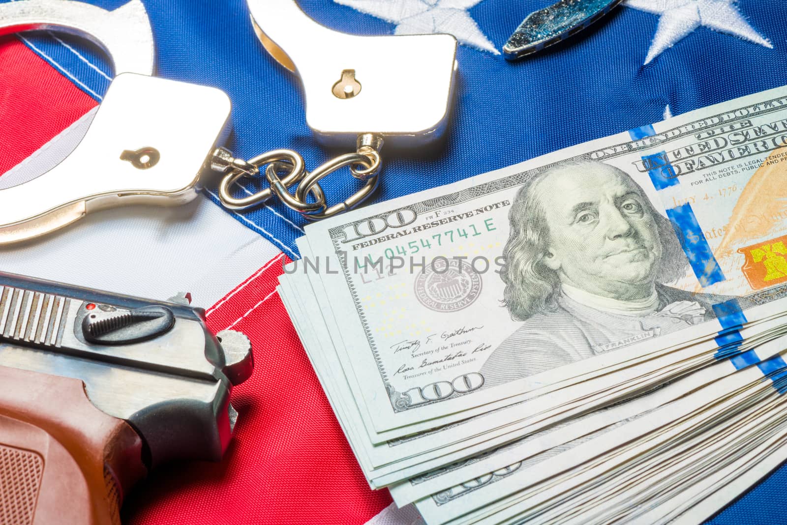Conceptual photo of the crime and money: dollars, handcuffs and by kosmsos111