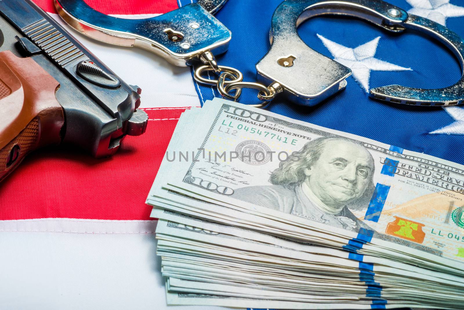 Withdrawn money and weapons on the American flag - a crime and punishment concept photo