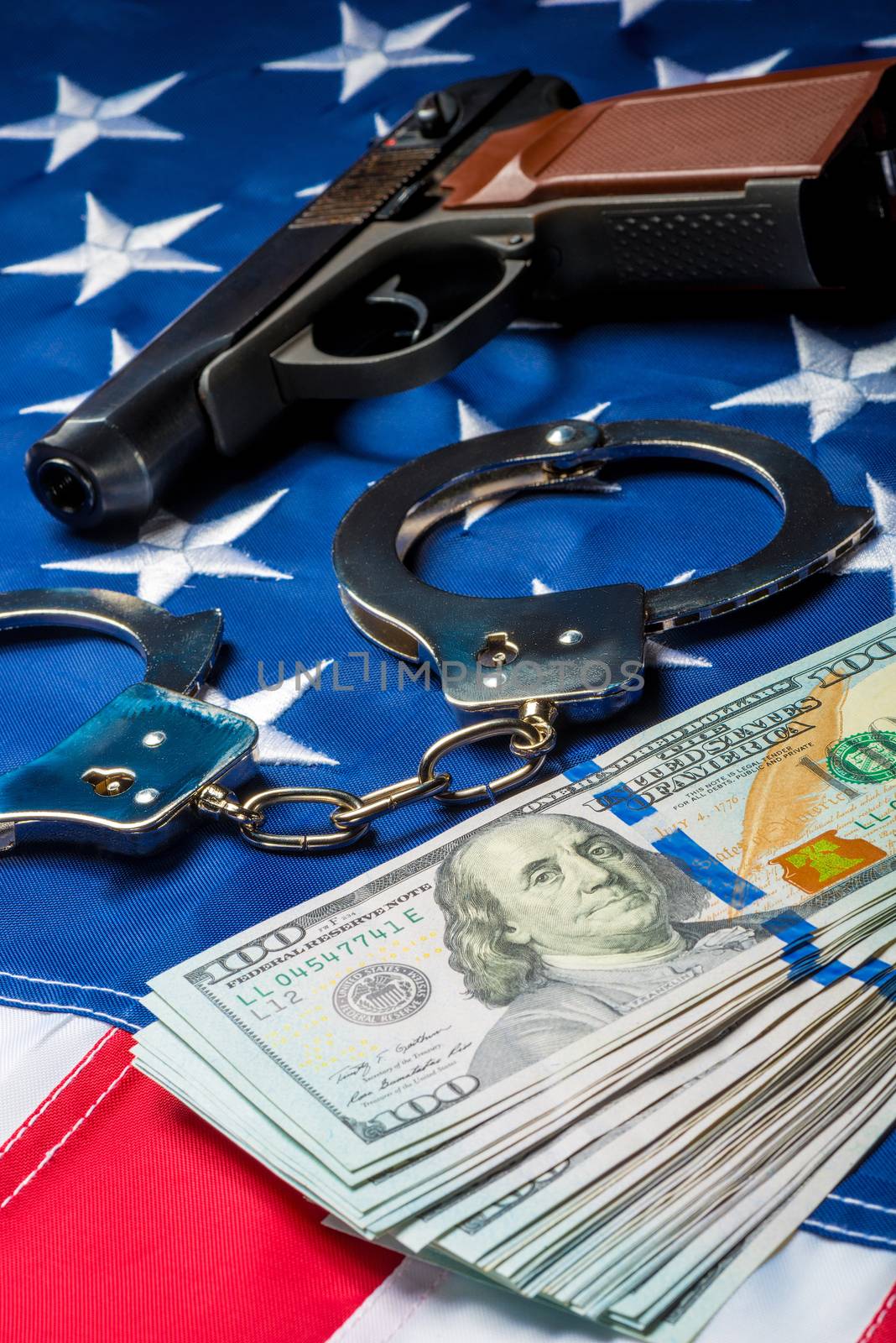 vertical concept photo of crime and punishment seized money and weapons on the American flag