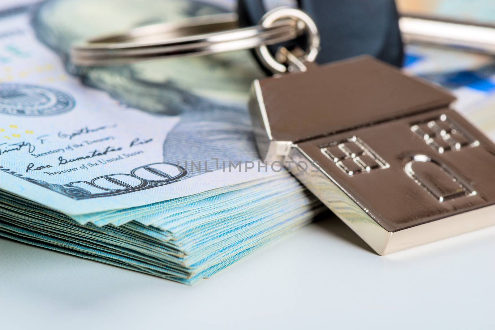 house key on a pile of american dollars on a white background close-up