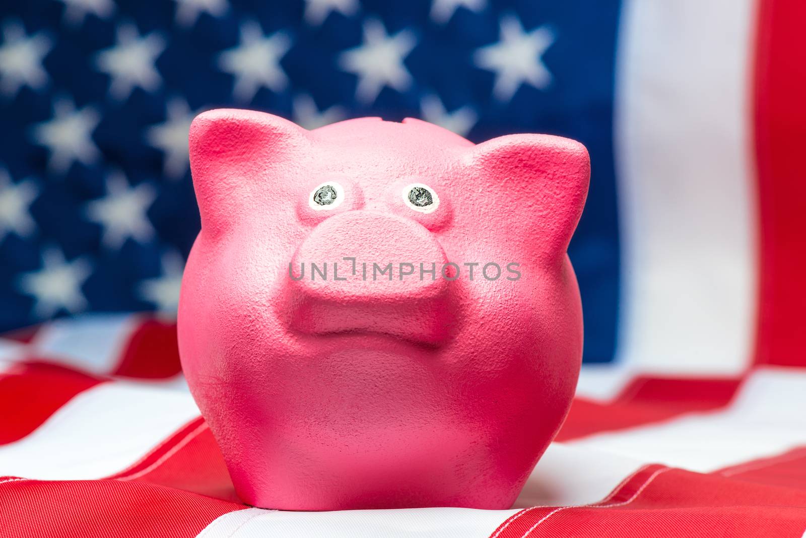 Pink piggy bank close up on American flag