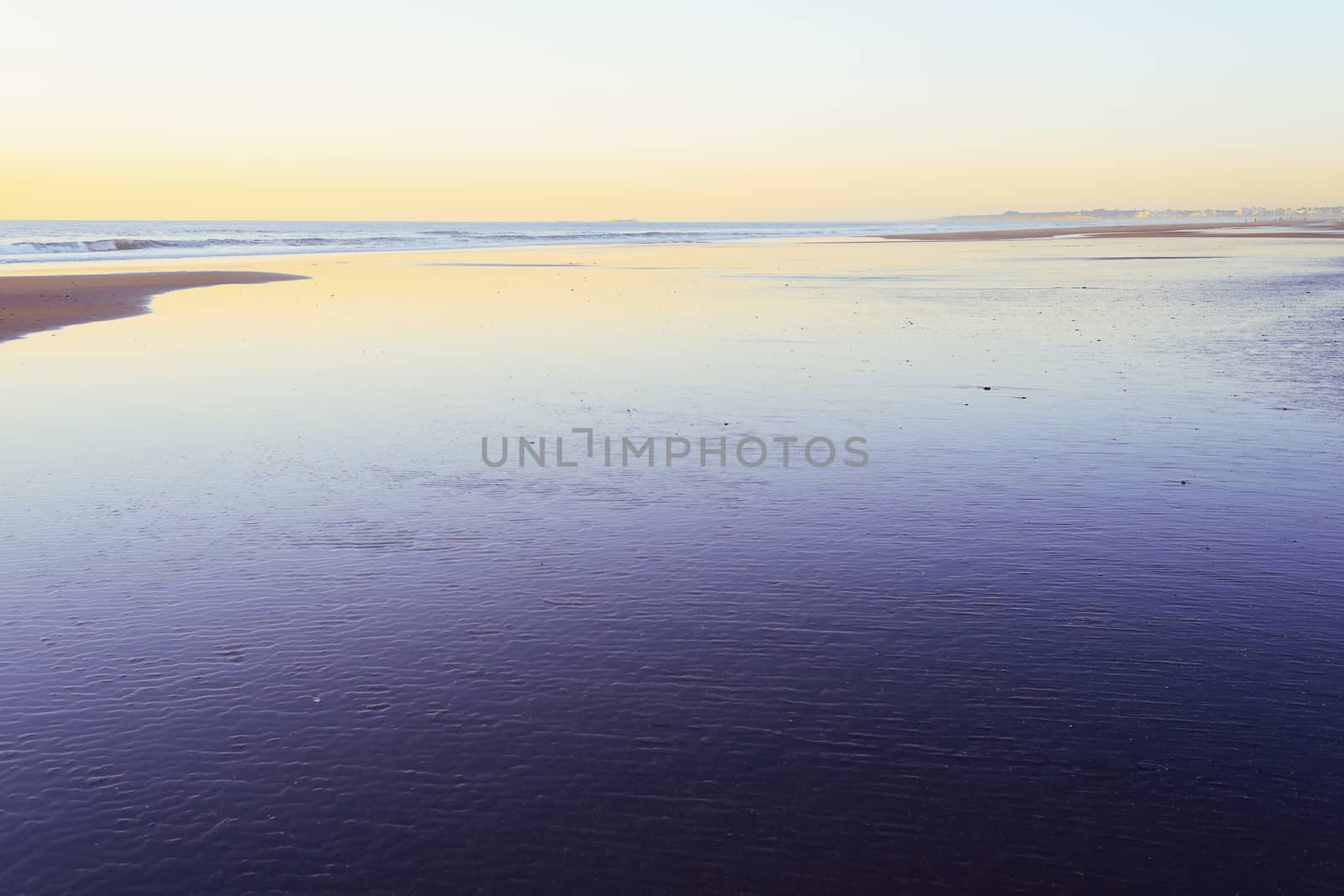 sunset on a lonely beach flooded by low tide, minimalist style