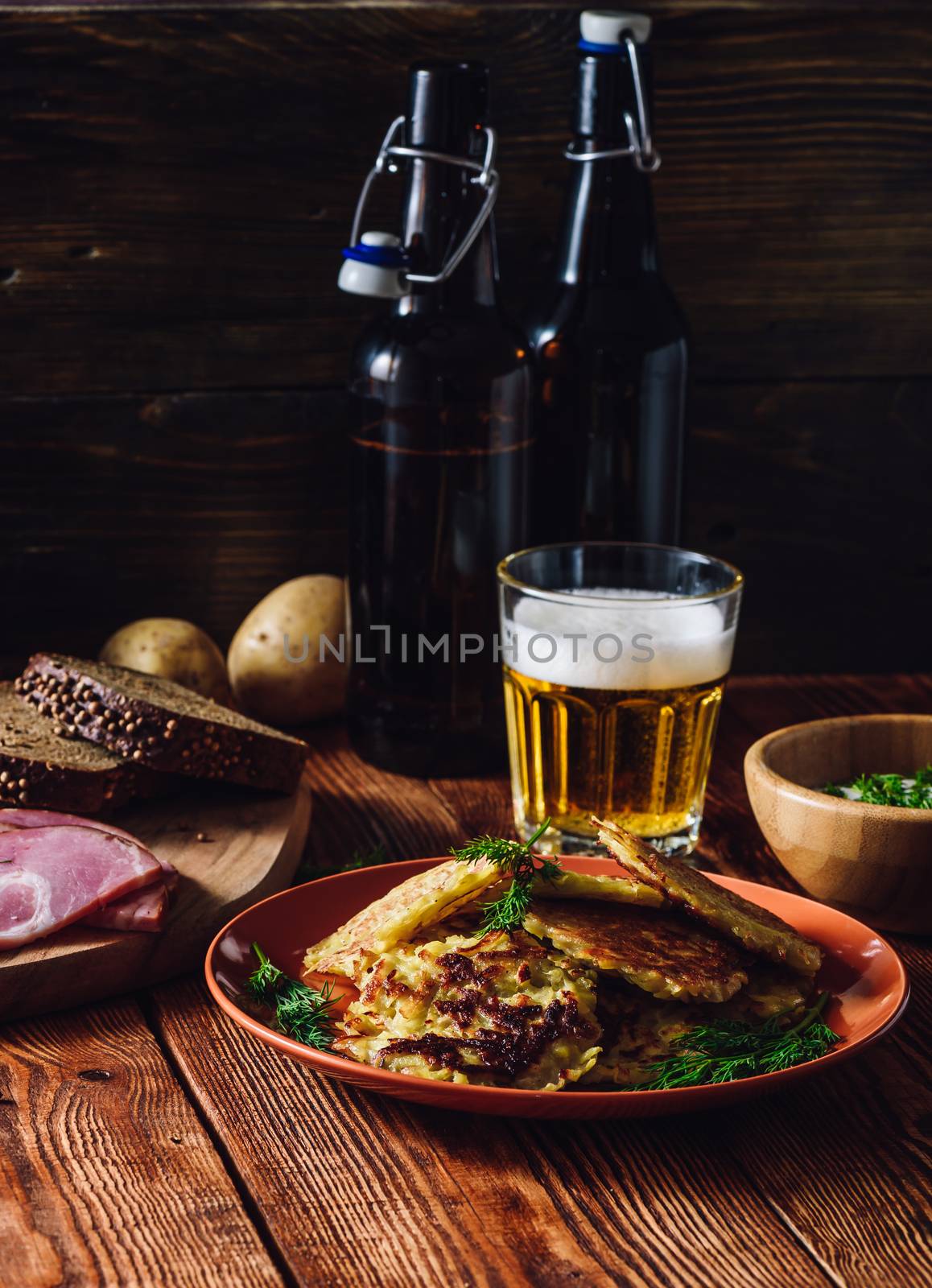 Glass of Beer with Potato Pancakes and Some Snacks. Vertical Orientation.