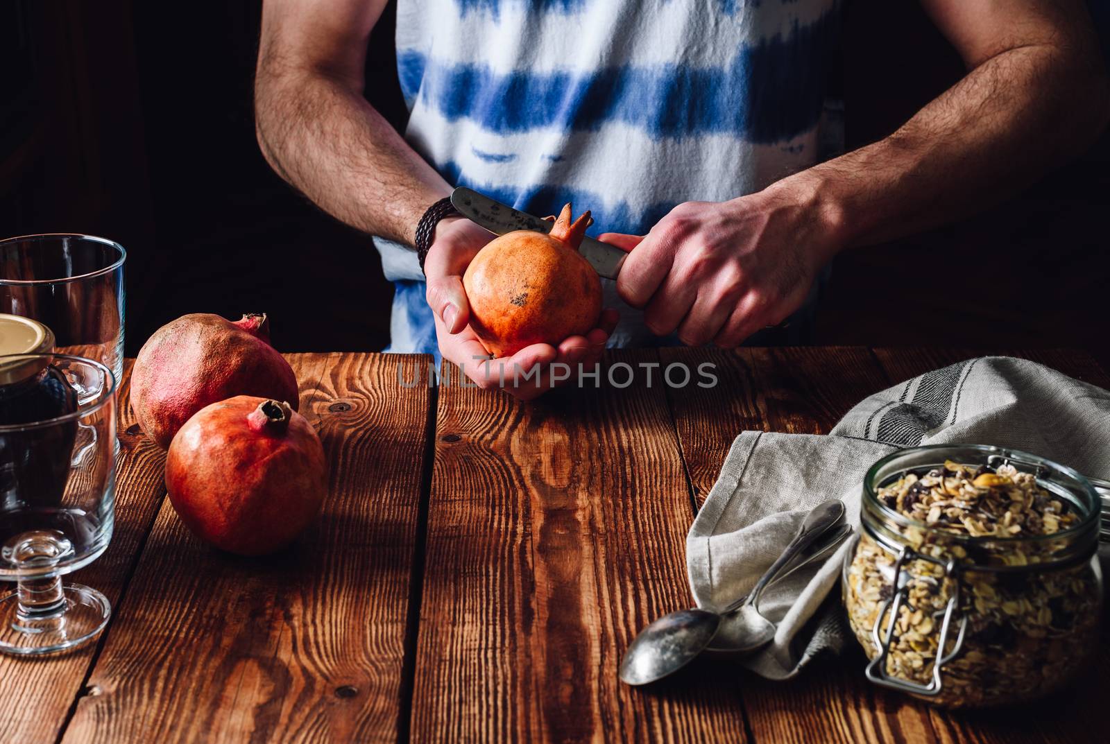 Man Opens Pomegranate with a Knife. by Seva_blsv