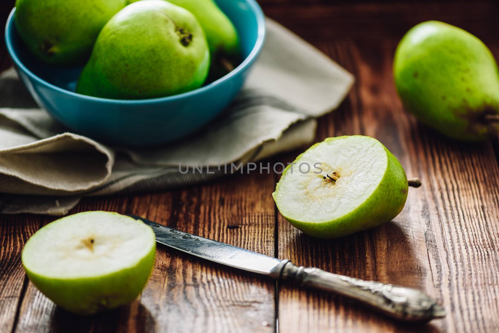 Sliced Pear with Knife and Some Pears on Background.