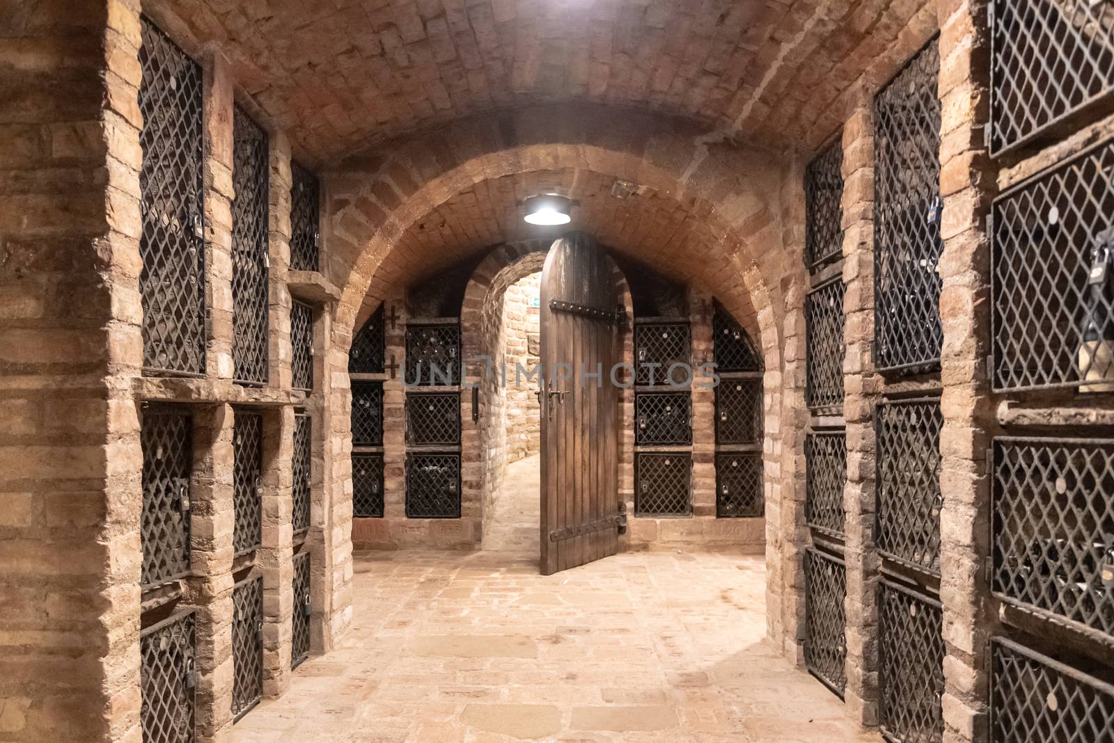 Old wine cellar with wine storage cases and open vintage wooden doors.