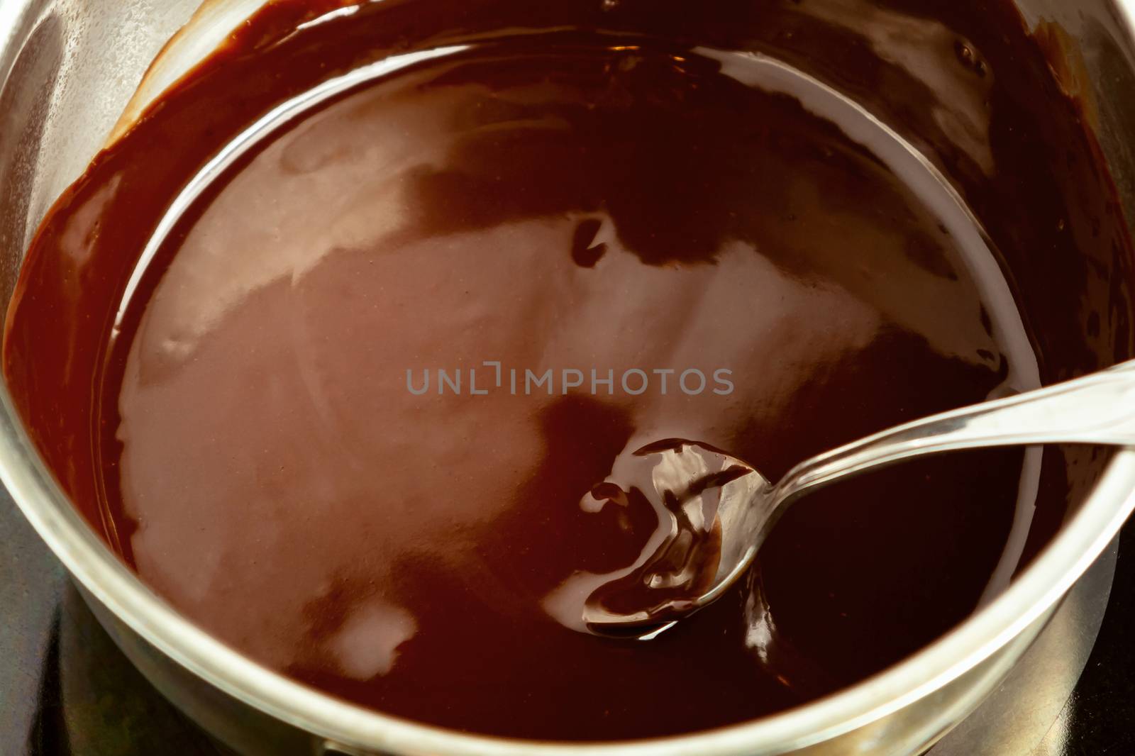 Melting dark chocolate in a saucepan on the stove by galsand
