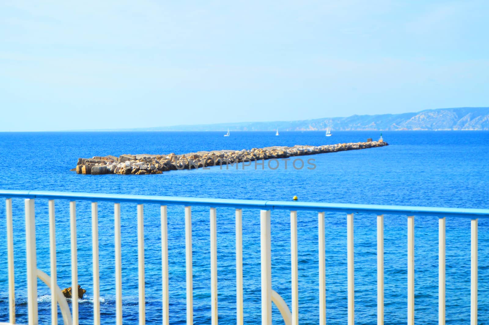 View of the calm blue sea with small yachts in the sea Bay from the waterfront. Luxury summer holiday on the French Riviera, a copy of the space.