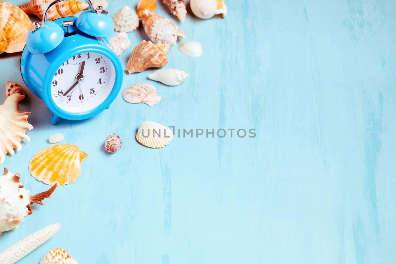 Blue sea background with alarm clocks and seashells, summer holiday and vacation time concept.