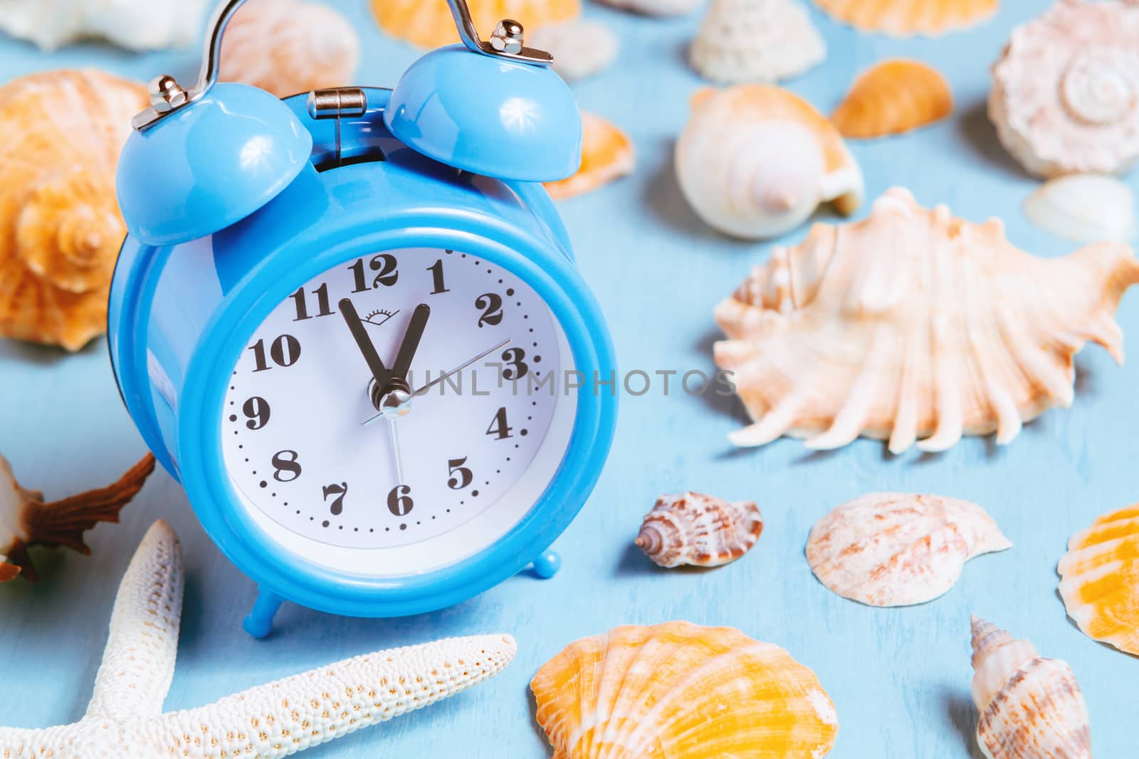 Blue sea background with alarm clocks and seashells, summer holiday and vacation time concept by galsand